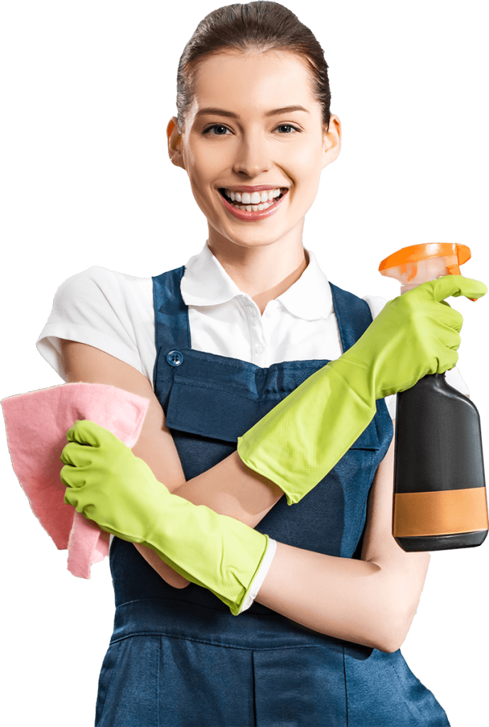 A smiling woman wearing a blue apron and green rubber gloves holds a spray bottle and a pink cloth, ready for cleaning. The background is black.